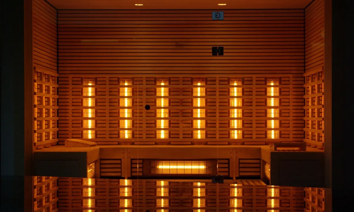 Interior of a cabinet-like enclosure with multiple vertical infrared heat lamps on both sides, glowing orange to illustrate heat distribution for tarantula habitats.